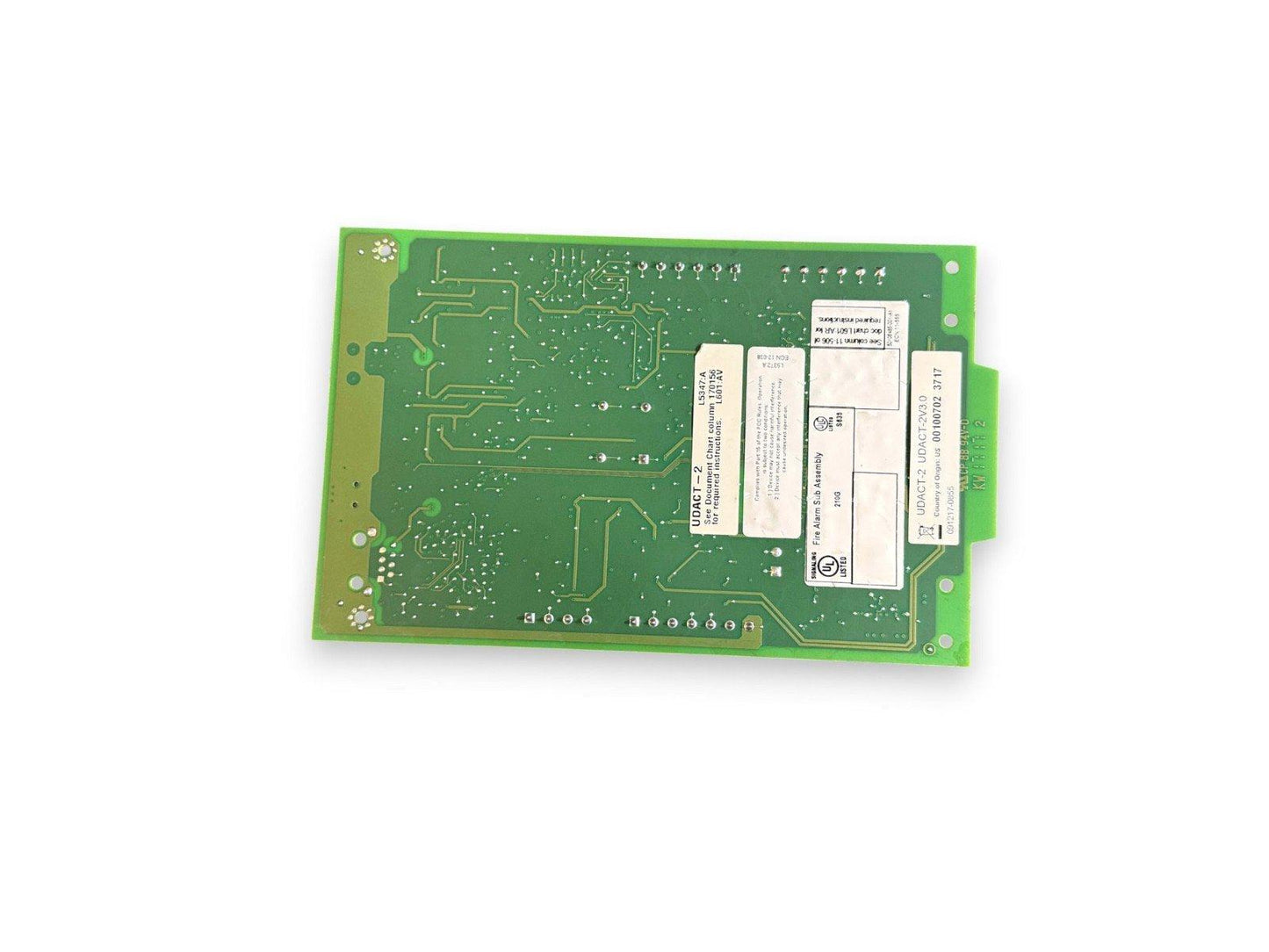 Green fire alarm control panel circuit board with UDACT-2 labels and UL listing for commercial safety systems