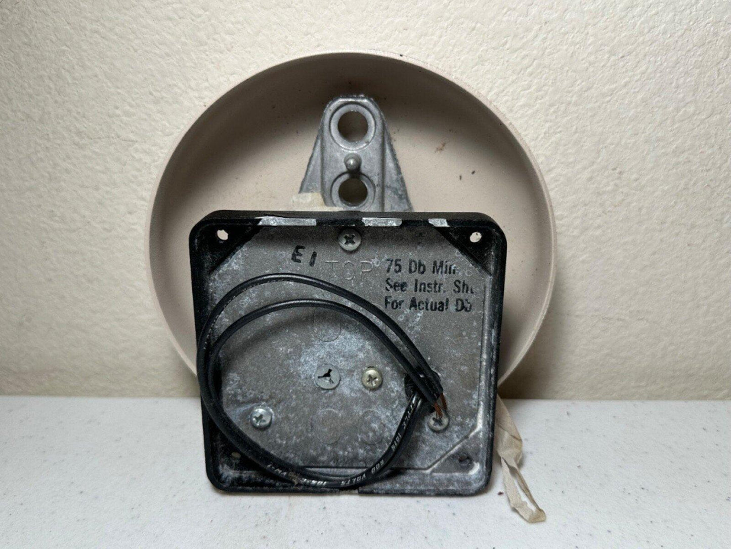 EI TOP fire alarm horn speaker with 75 Db rating, mounted on wall, showing wiring and bracket