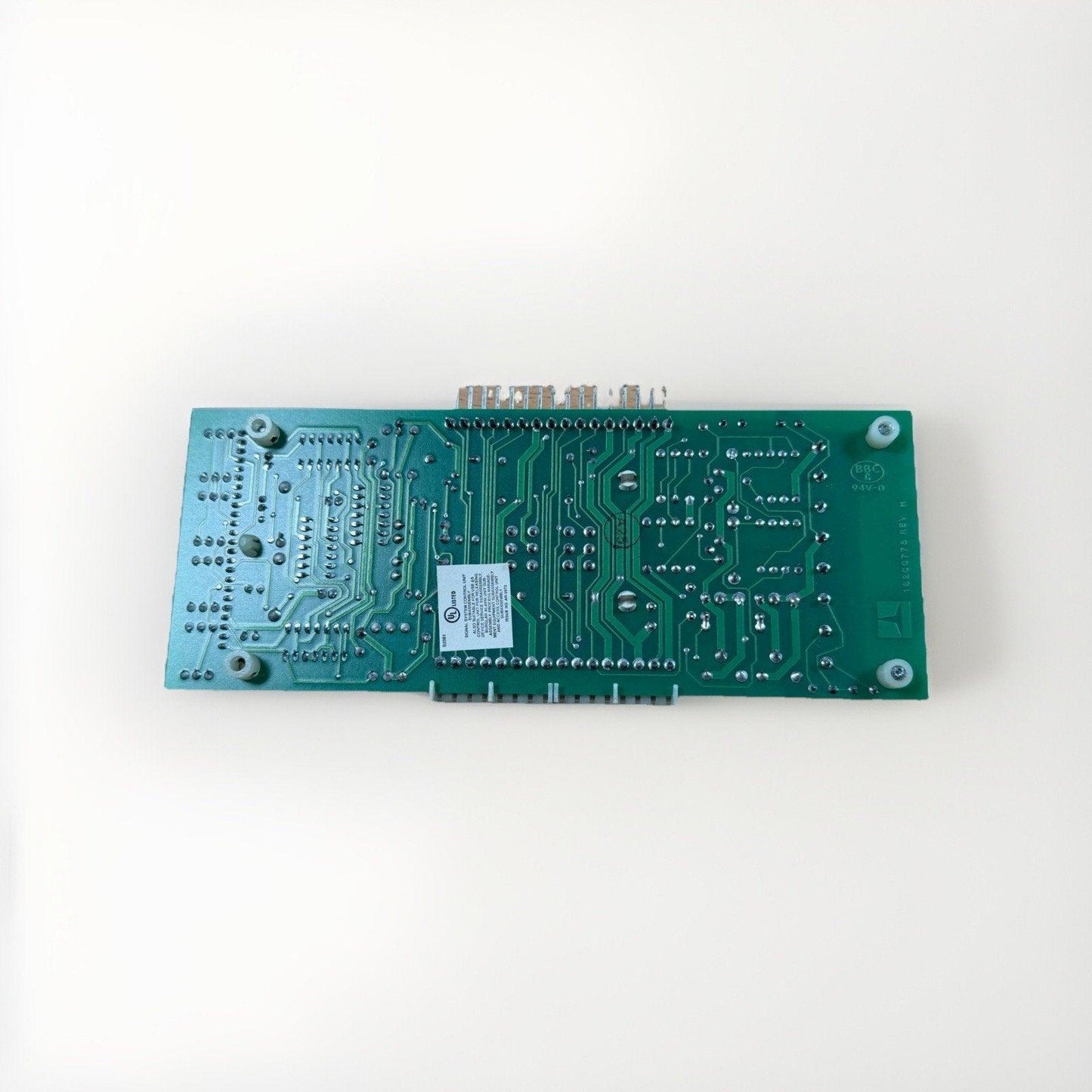 Green fire alarm control panel circuit board with UL label, connectors, and mounting holes for system integration