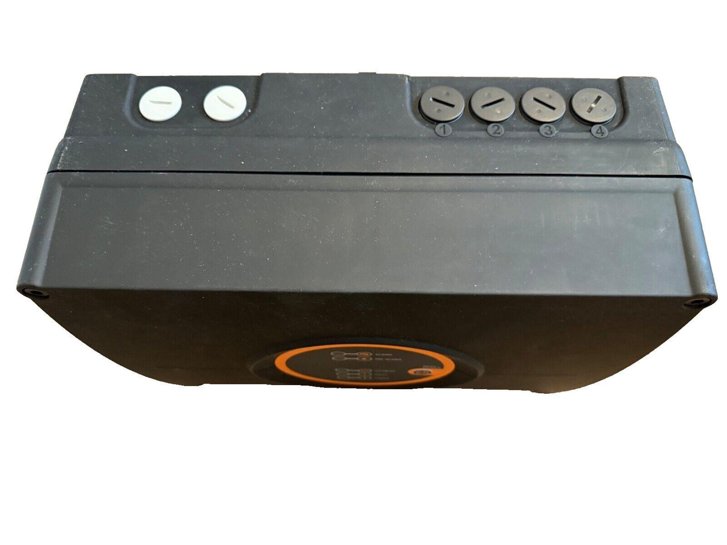Black fire alarm control panel with four numbered switches and two white buttons, featuring orange indicator light