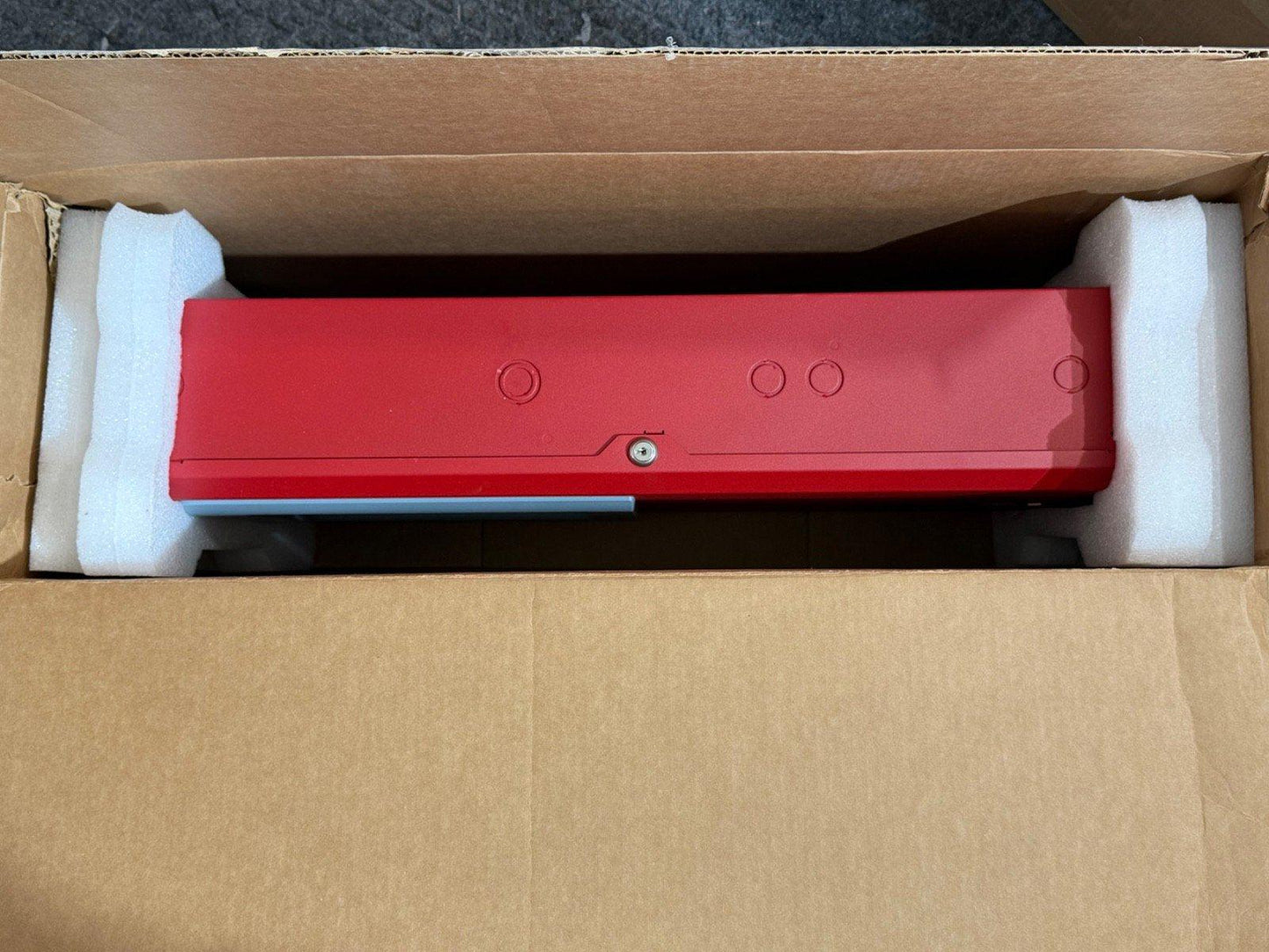 Red fire alarm control panel in shipping box with foam protection