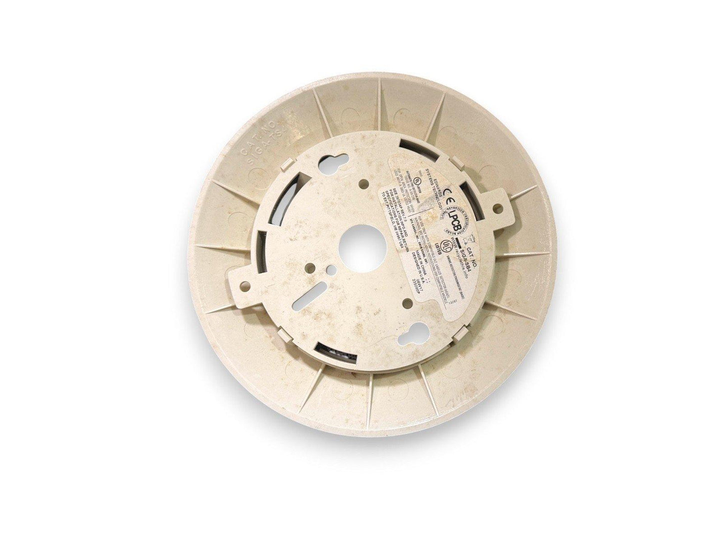 Used fire alarm base plate with mounting slots and certification labels, compatible with smoke detectors