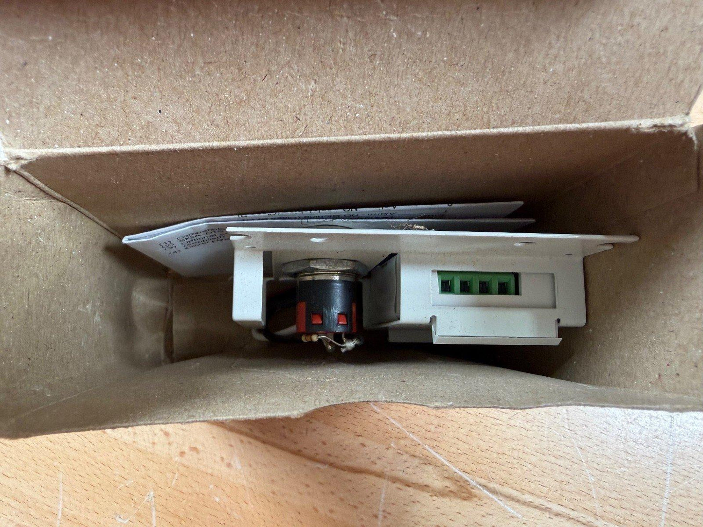 Fire alarm pull station with green terminal block inside cardboard box, used fire safety equipment