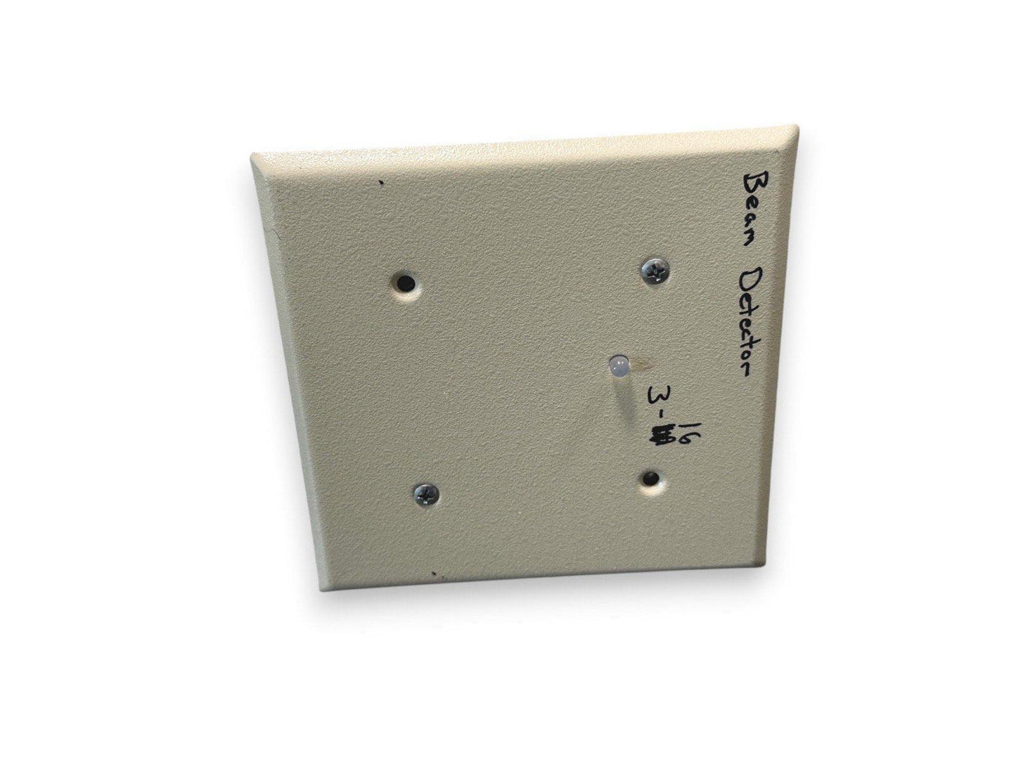 Beam detector fire alarm device with handwritten label, beige square panel, mounting screws visible