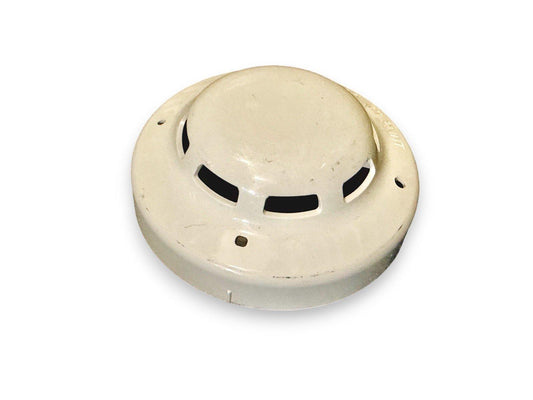 Used fire alarm smoke detector with vented cover, off-white ceiling mount device