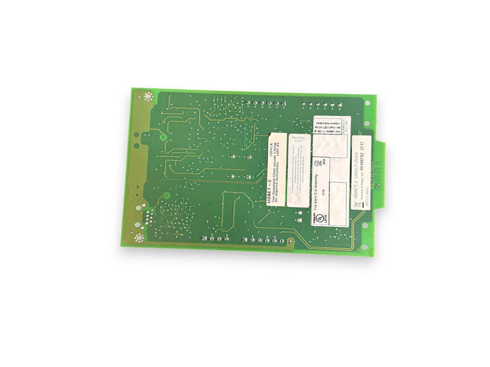 Green fire alarm control panel circuit board with UDACT-2 labels and UL listing for commercial safety systems