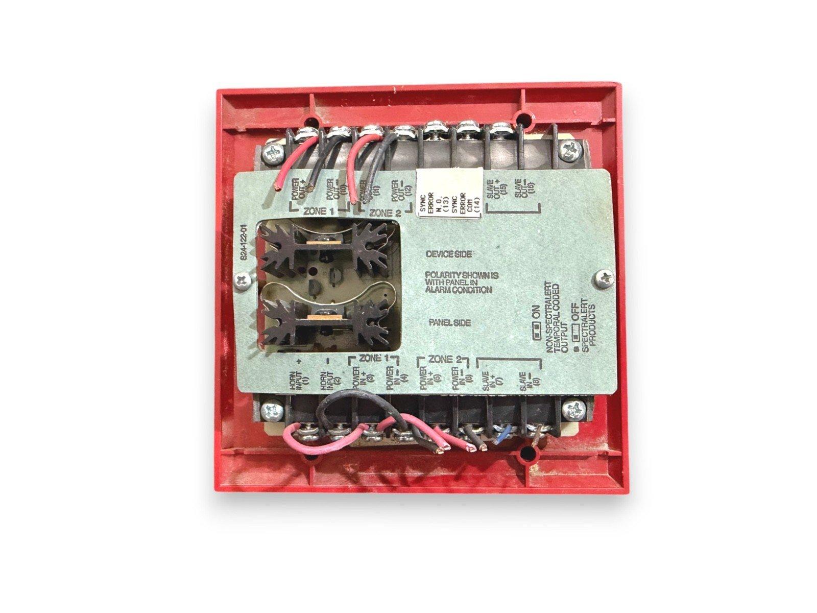 Red fire alarm control module with labeled terminals and wiring for Zone 1 and Zone 2