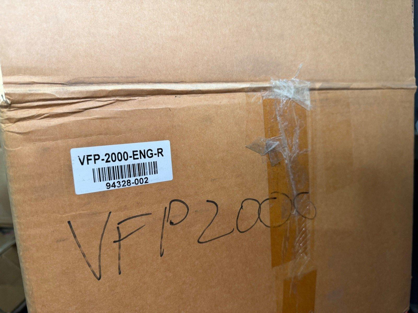 VFP-2000-ENG-R fire alarm equipment box with barcode and handwritten label, ready for shipping