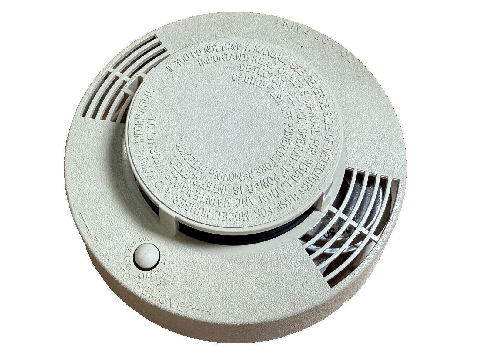 White smoke detector with test button and installation instructions, fire alarm safety device