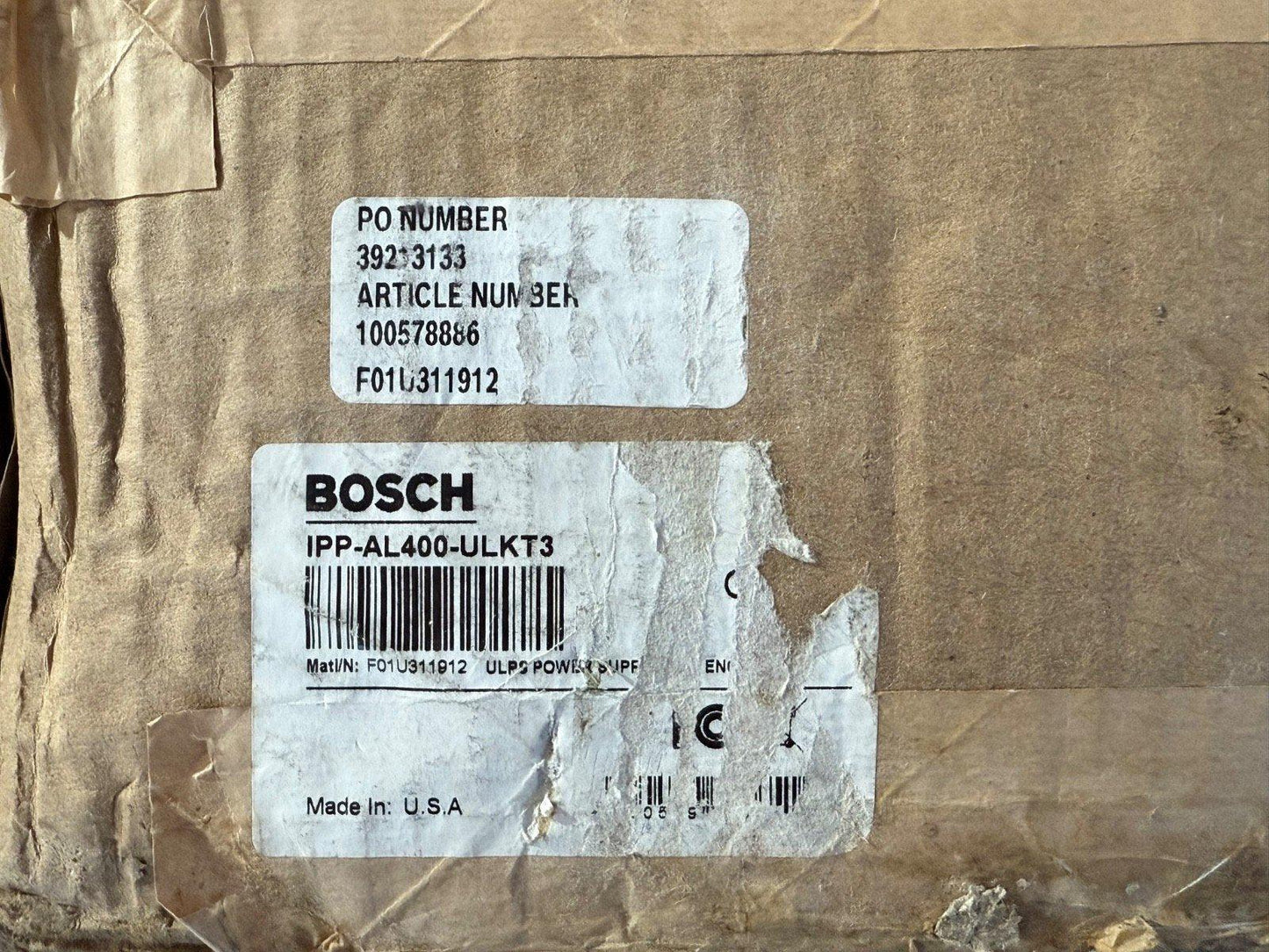 Bosch IPP-AL400-ULKT3 fire alarm power supply, made in USA, on shipping box with PO and article numbers