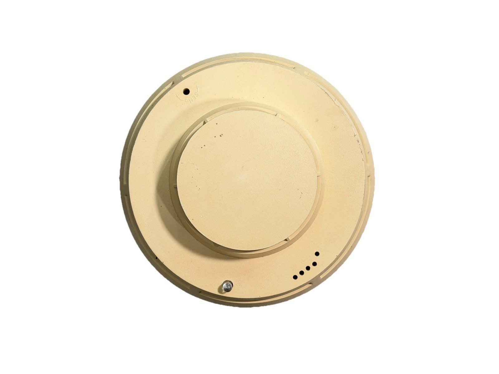Beige ceiling-mounted fire alarm detector with mounting holes and sensor vents