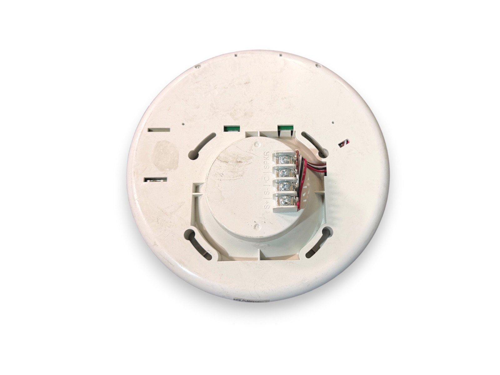 White fire alarm detector base with wiring terminals and mounting slots for commercial or residential use