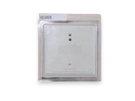 M500X fire alarm control panel module in clear packaging, silver metal casing with caution label