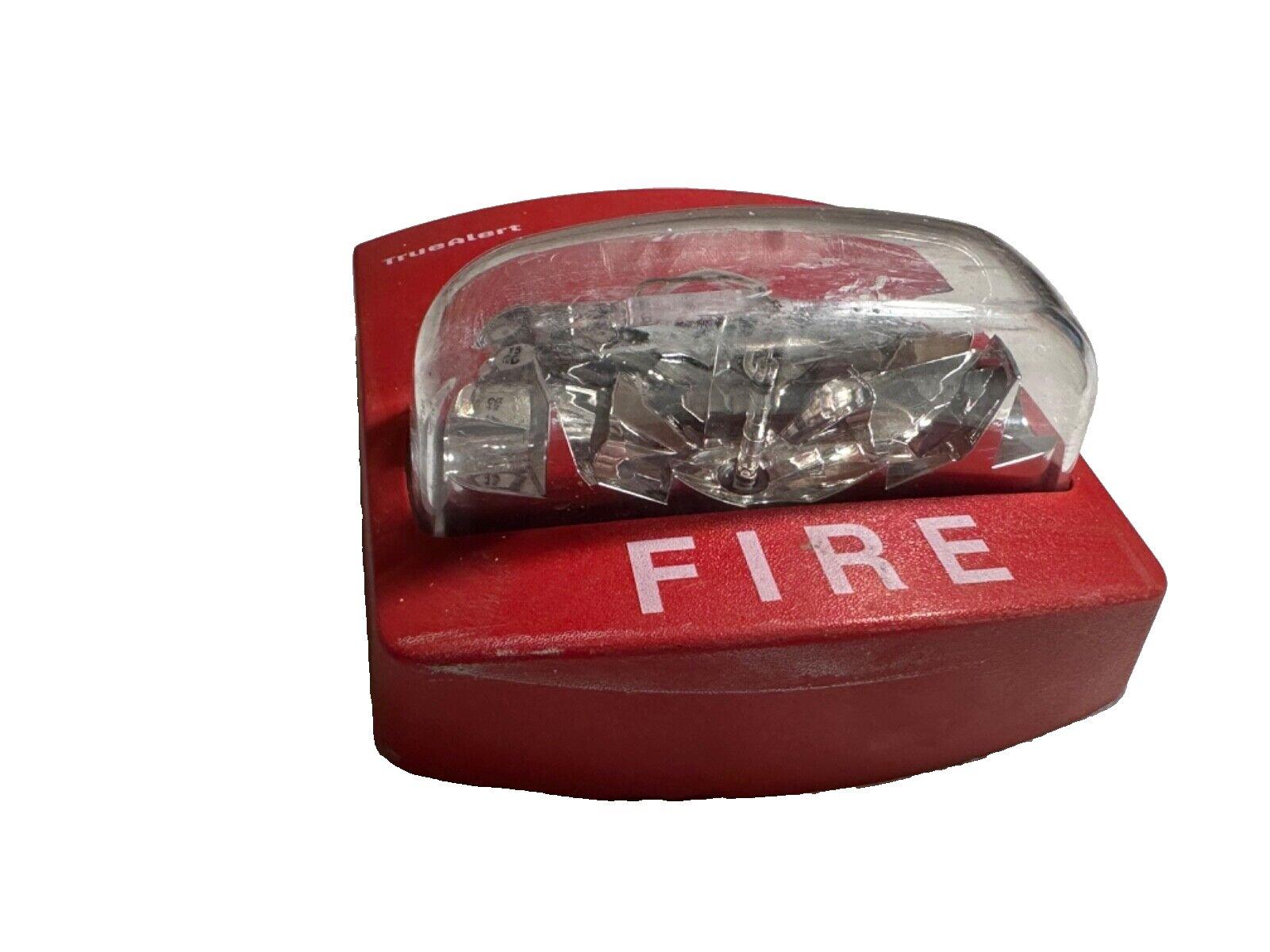 Red TrueAlert fire alarm strobe light with clear lens and FIRE label, used fire safety equipment