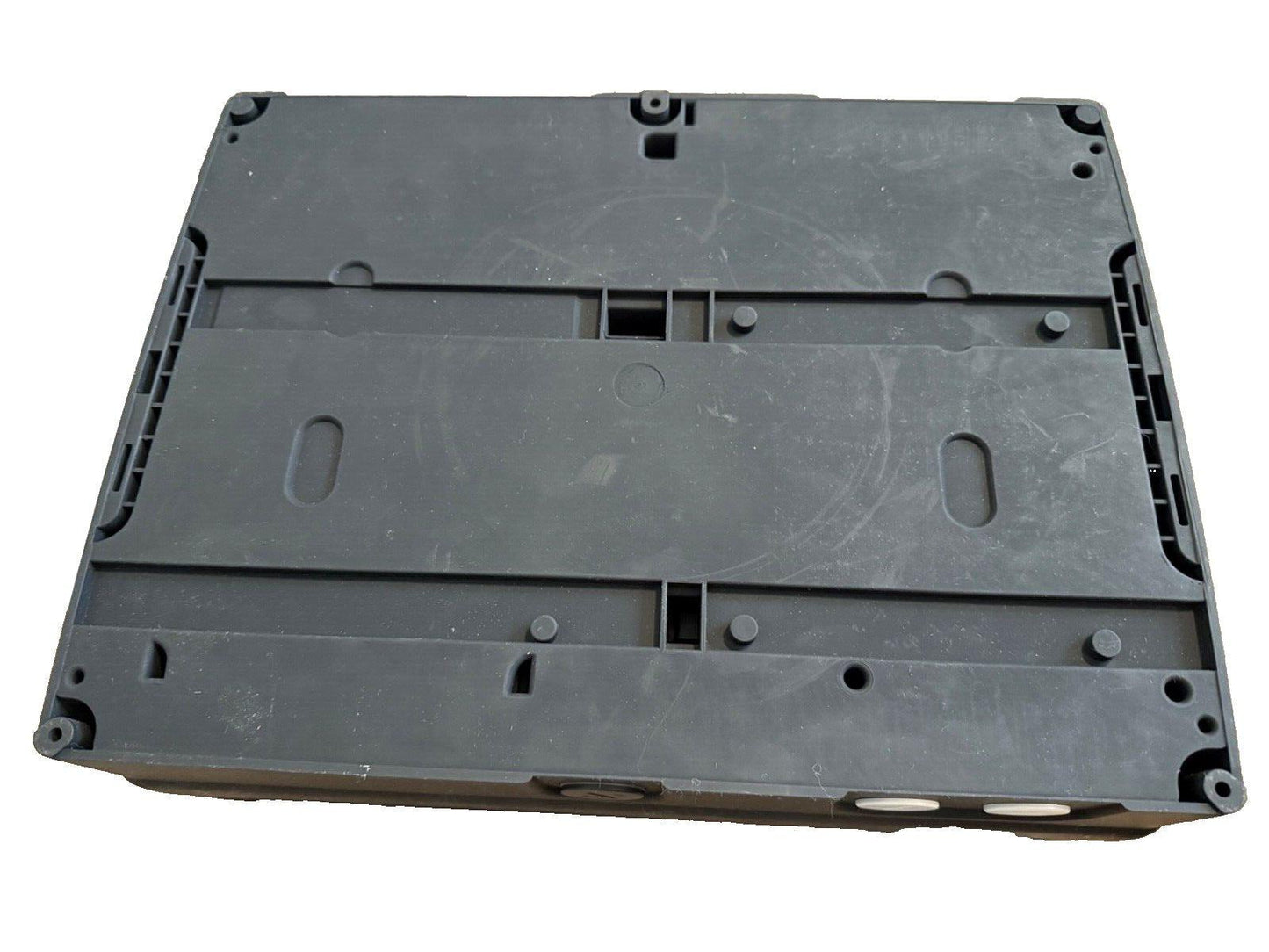 Black plastic fire alarm control panel back cover with mounting holes and slots