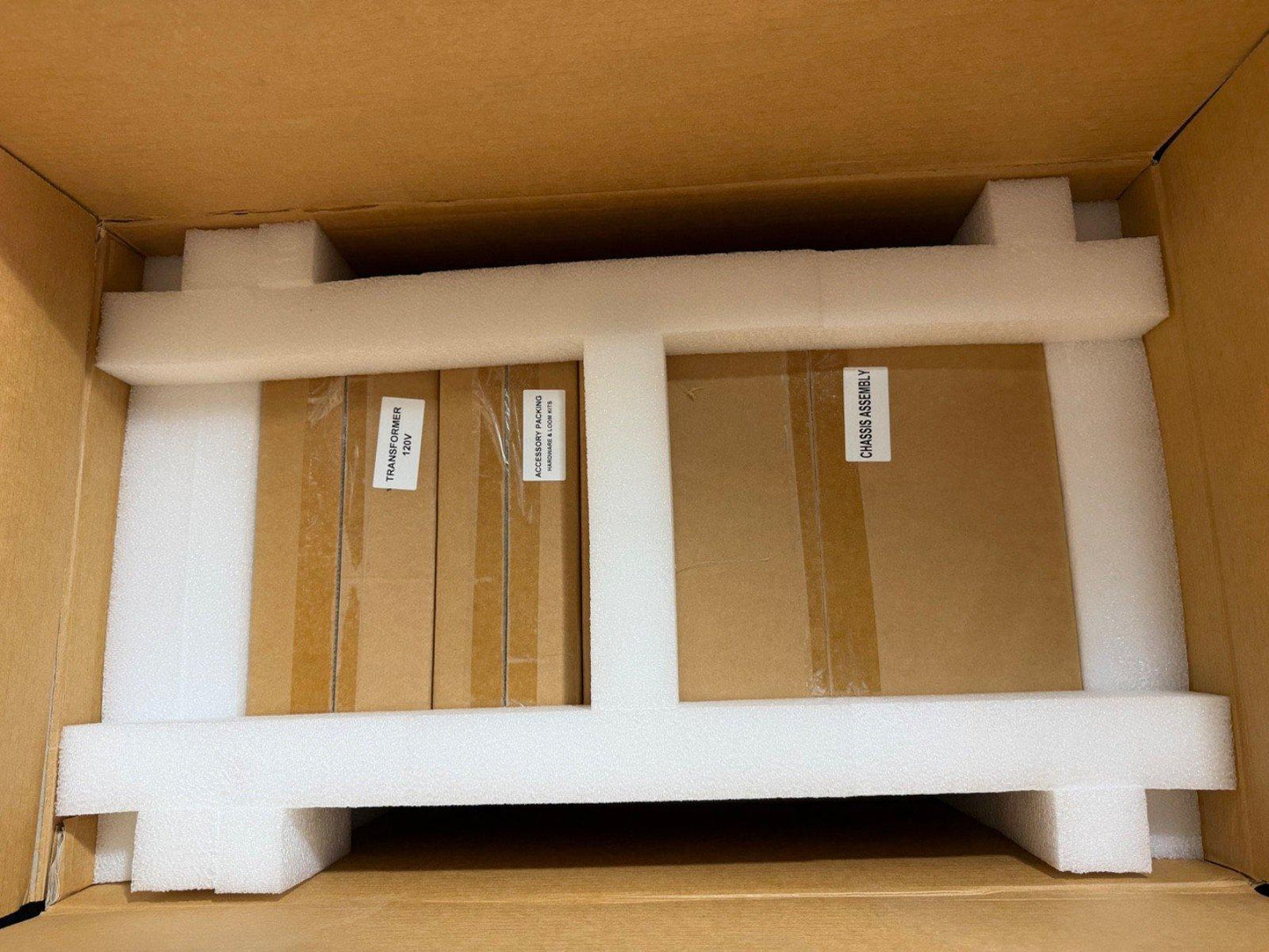 Fire alarm system components packed in foam: transformer, chassis assembly, and accessories