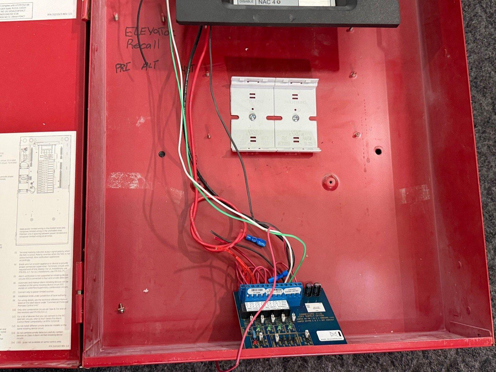 Red fire alarm control panel with wiring and circuit board, labeled NAC 4.0 and Elevator Recall