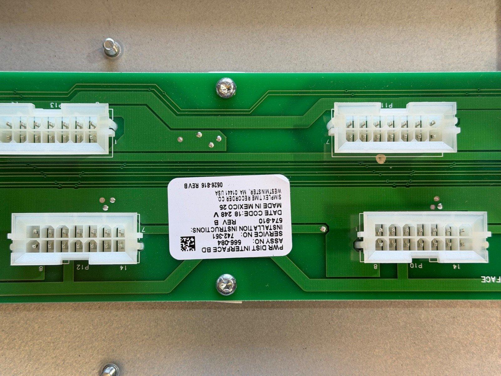 Green fire alarm control panel circuit board with white connectors and label, used fire alarm equipment