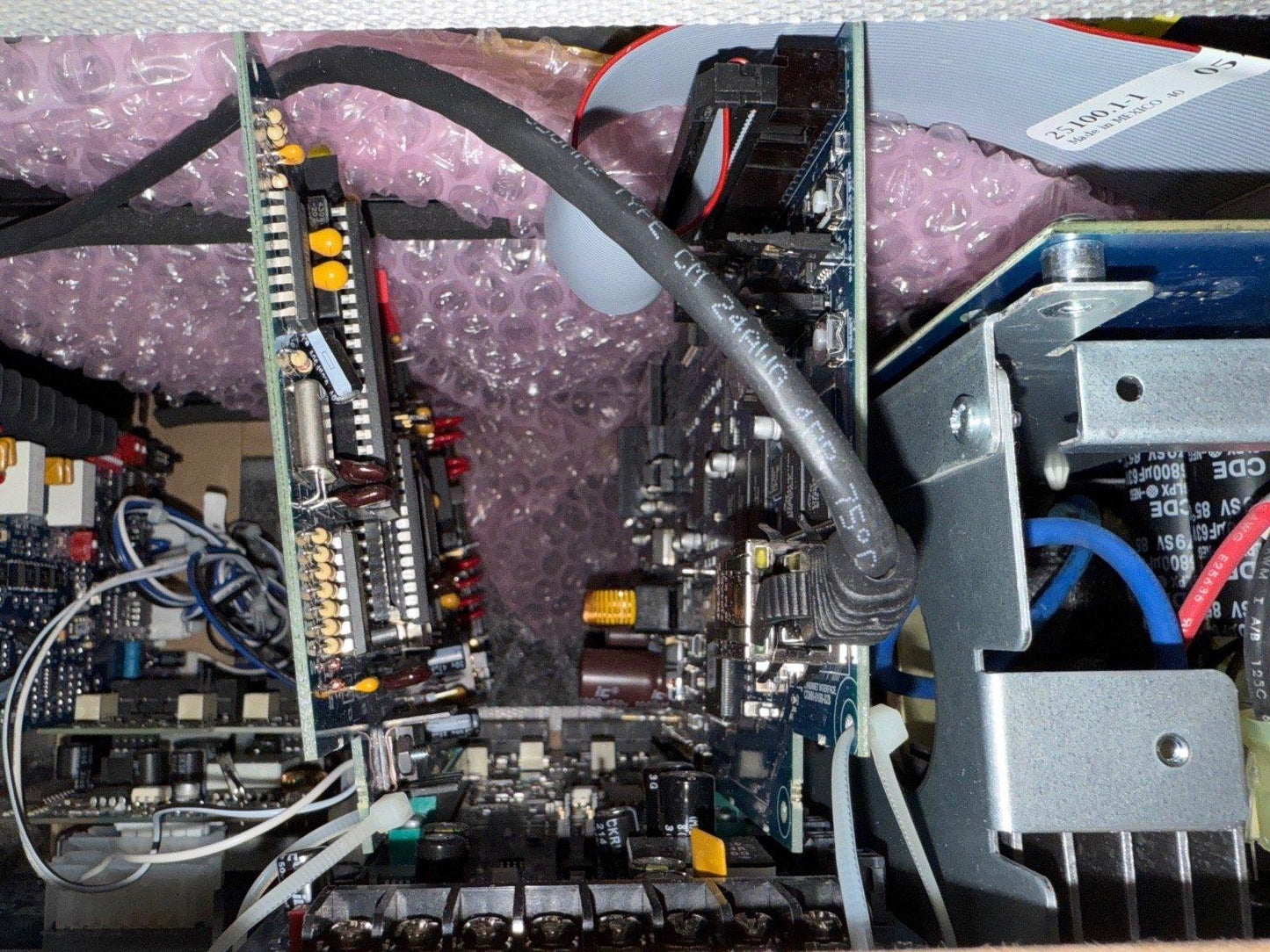 Fire alarm control panel circuit board with wiring and components, packaged for shipping