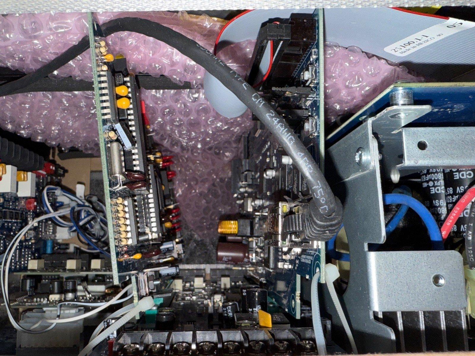 Fire alarm control panel circuit board with wiring and components, packaged for shipping