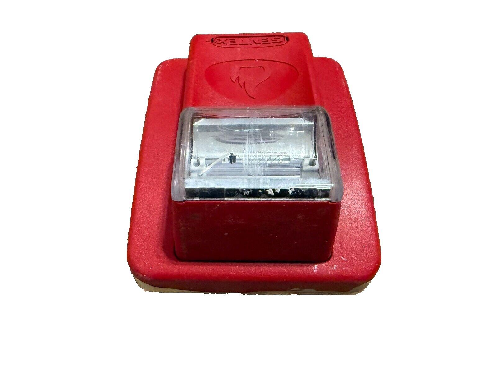 Red Gentex fire alarm pull station with clear cover and flame logo, used fire safety equipment