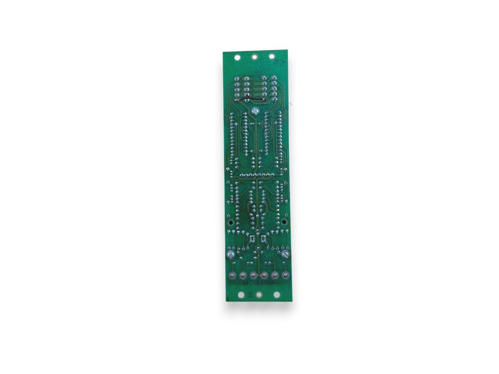 Green fire alarm control panel circuit board with solder points and mounting holes