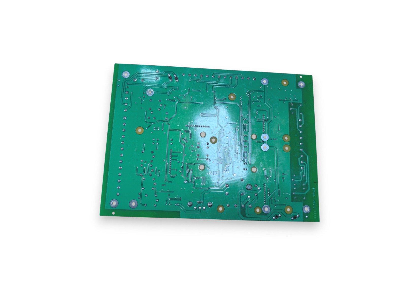 Green fire alarm control panel circuit board with solder points and traces