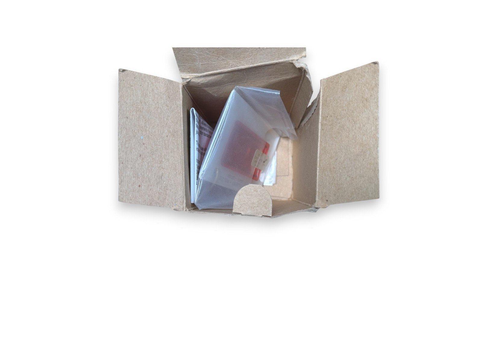 Fire alarm component in open box with manual, ready for installation or replacement