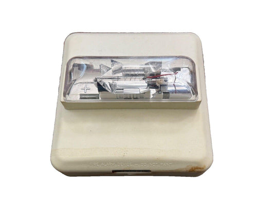 Used fire alarm strobe light with clear lens and internal components visible, labeled 'FIRE ALARM DEVICE'