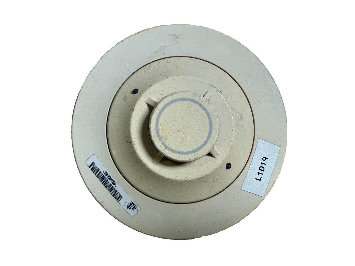 Used fire alarm detector with L1D19 label, circular beige design, barcode sticker, for fire safety systems