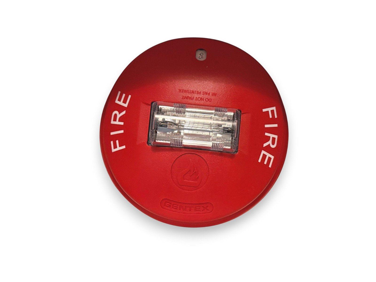 Red Gentex fire alarm strobe with 'FIRE' text and flame symbol, used in fire safety systems.