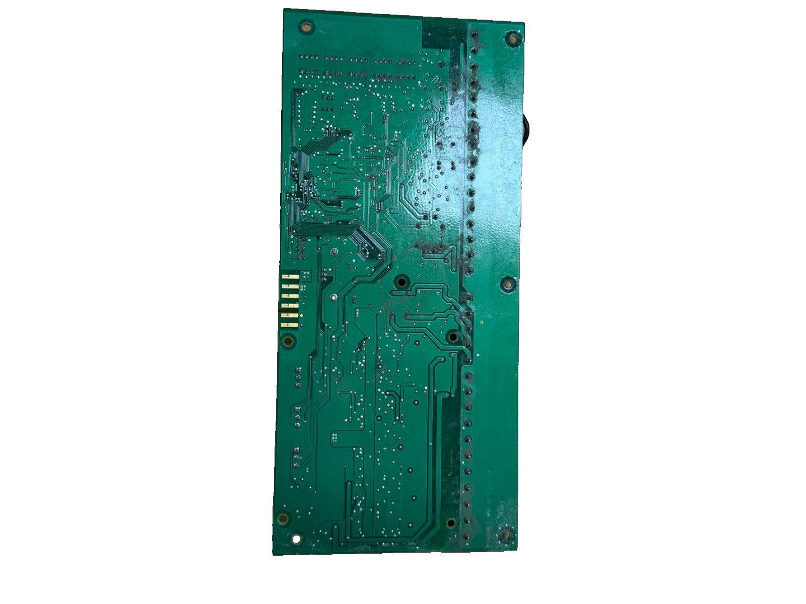 Green fire alarm control panel circuit board with solder points and mounting holes