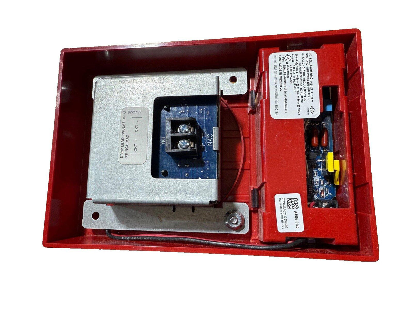 Red fire alarm control panel with internal circuitry and wiring terminals for fire safety systems