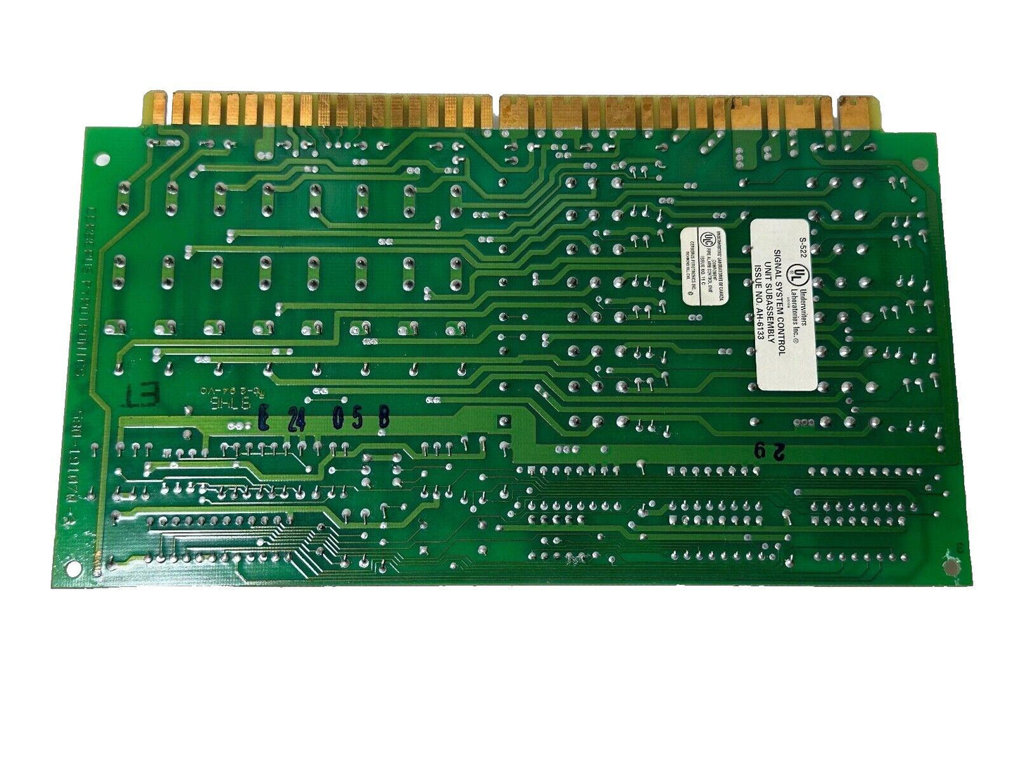 Green fire alarm control panel circuit board with UL label, gold connectors, and signal system subassembly markings