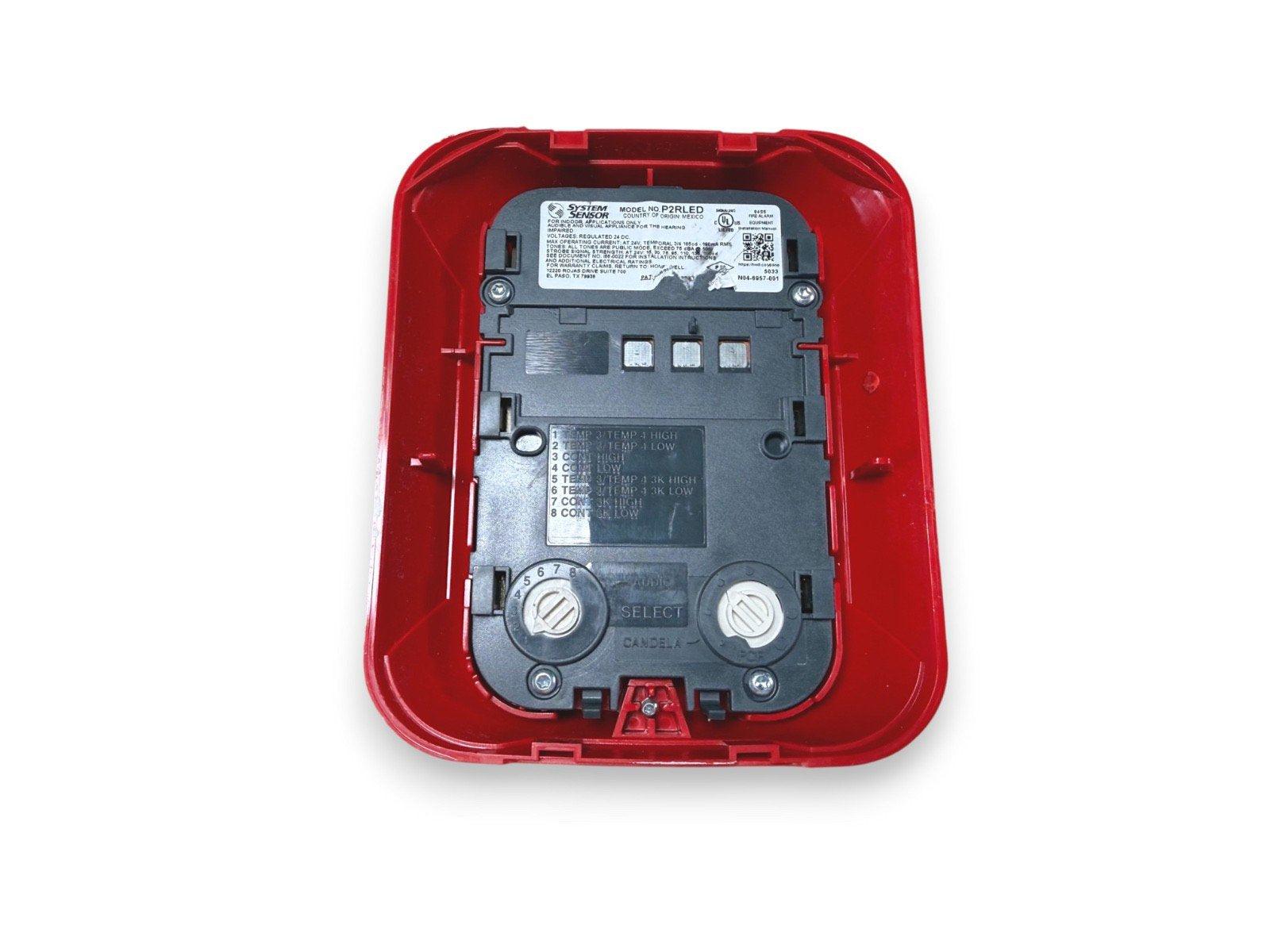 System Sensor P2RLED fire alarm device with red cover, showing wiring terminals and model label for commercial use