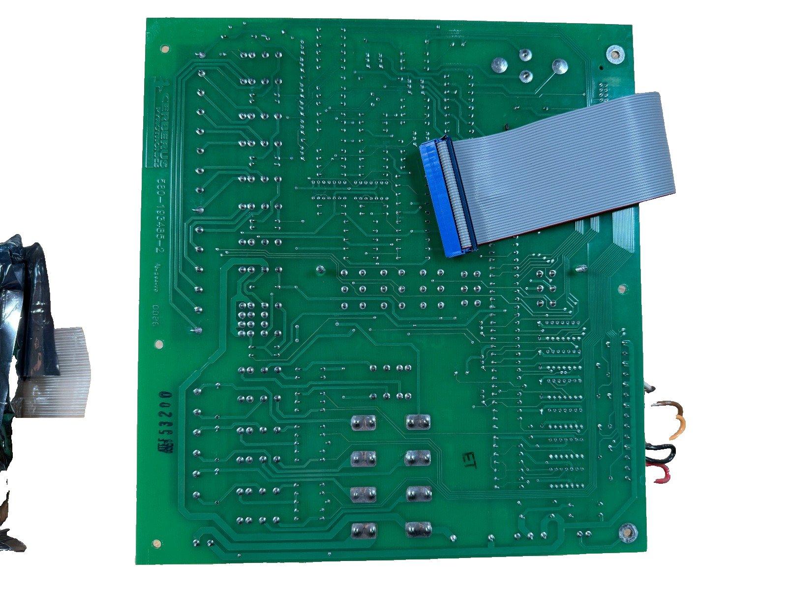 Green fire alarm control panel circuit board with ribbon cable and wiring terminals