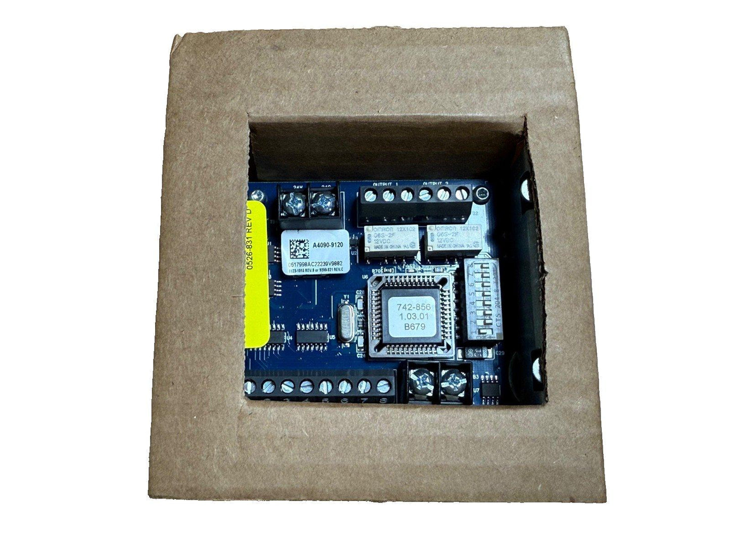 Fire alarm control module with circuit board, terminals, and chip, packaged in cardboard box