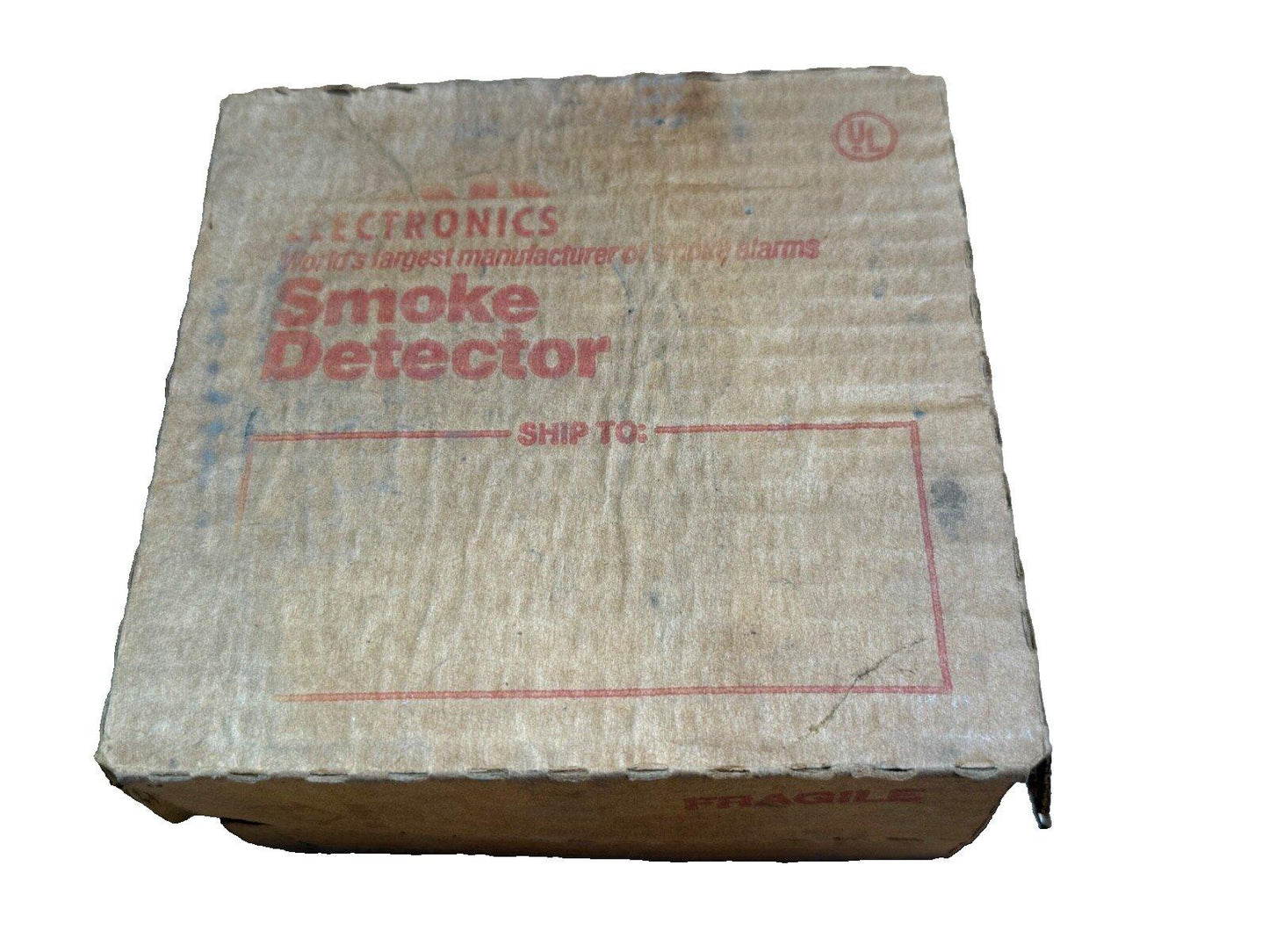 Used smoke detector in original cardboard box with UL logo, labeled 'Smoke Detector' and 'Fragile'