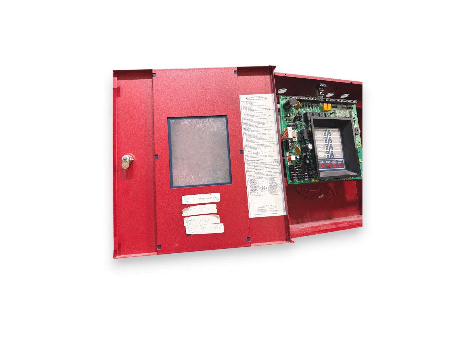 Red fire alarm control panel with open door showing circuit board and keypad for commercial fire safety systems