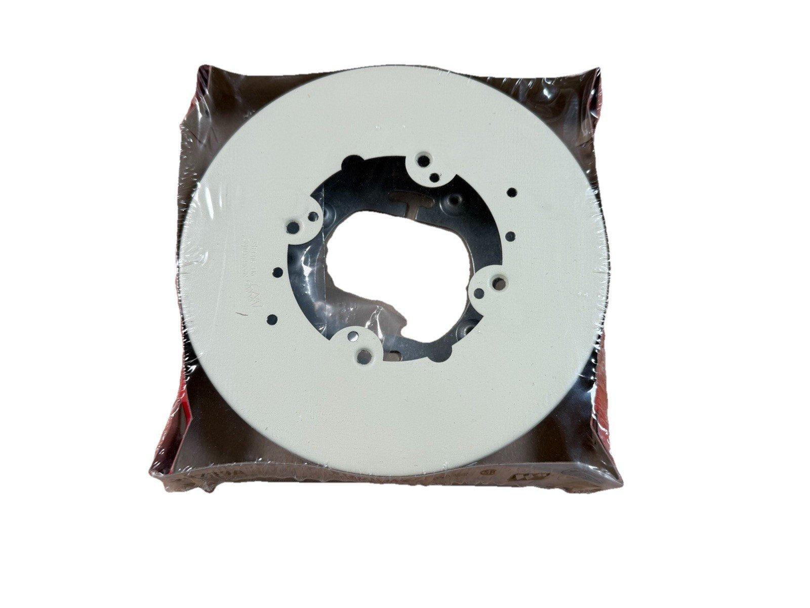 White fire alarm base plate with mounting holes, sealed in plastic packaging