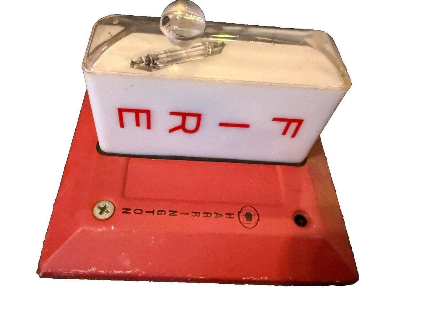 Red base fire alarm strobe light with clear cover and red lettering, used fire safety equipment