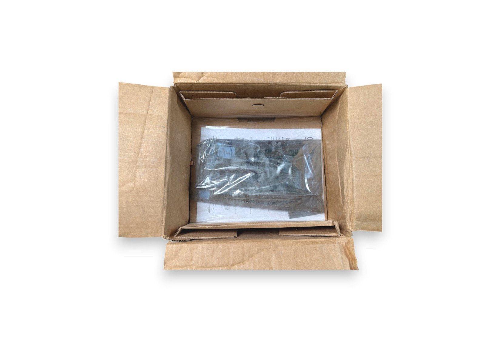 Open cardboard box with fire alarm equipment sealed in plastic, ready for shipping