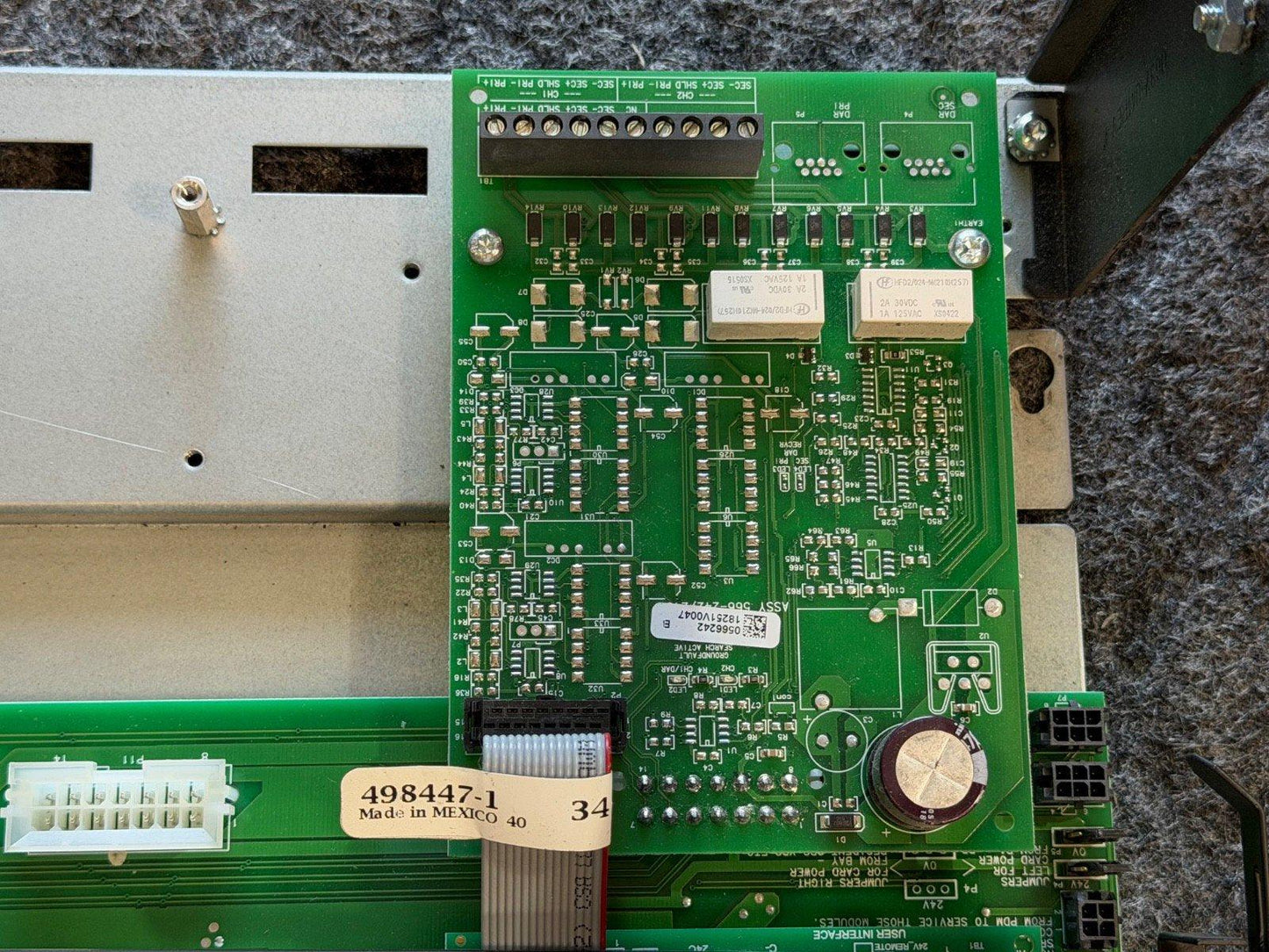 Green fire alarm control panel circuit board with connectors and components, labeled 498447-1, made in Mexico