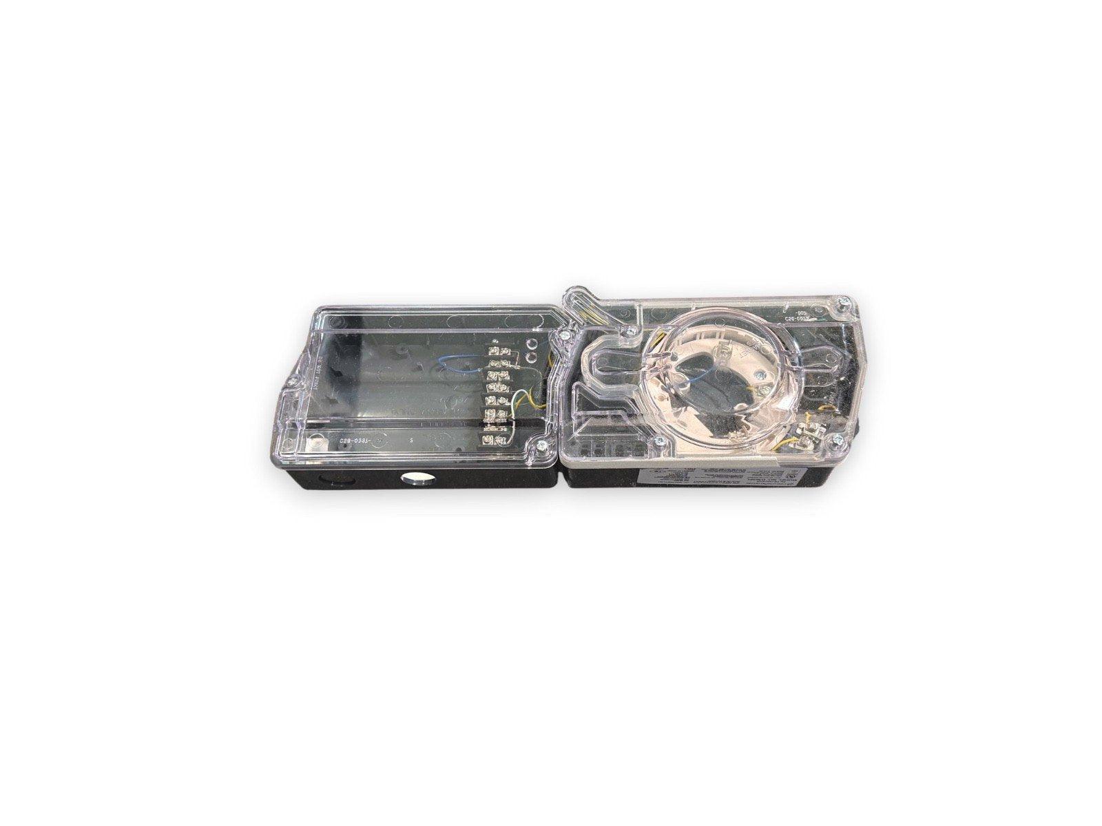 Fire alarm strobe light with clear cover, exposed wiring and mounting base for commercial safety systems