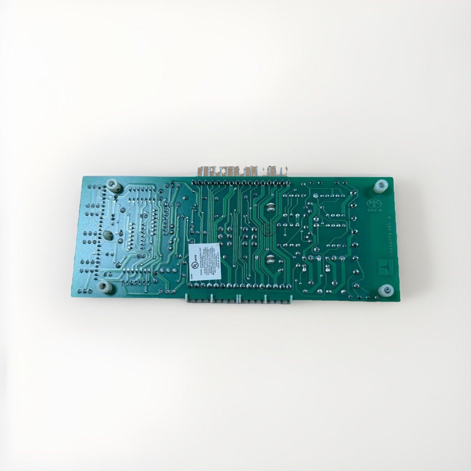 Green fire alarm control panel circuit board with UL label, connectors, and mounting holes for system integration