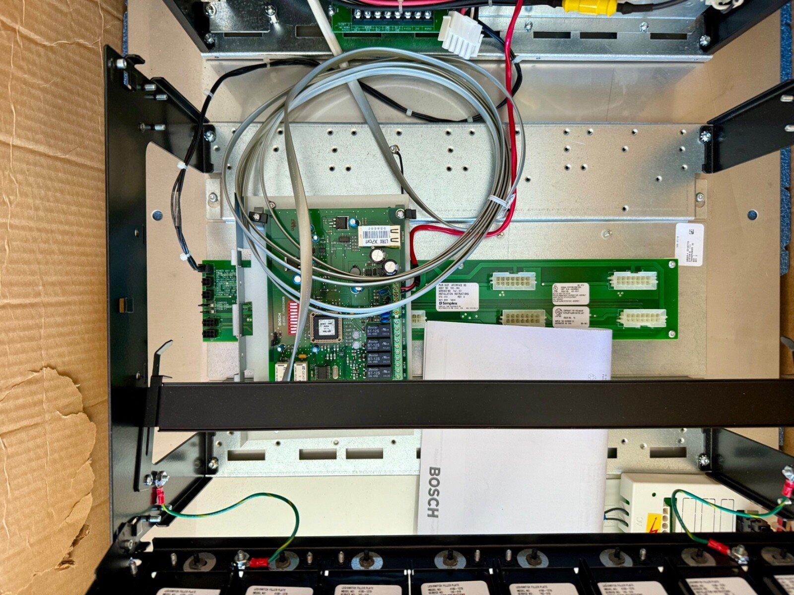 Bosch fire alarm control panel with circuit boards and wiring inside metal enclosure
