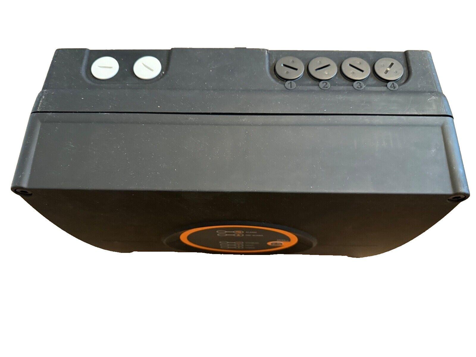 Black fire alarm control panel with four numbered switches and two white buttons, featuring orange indicator light