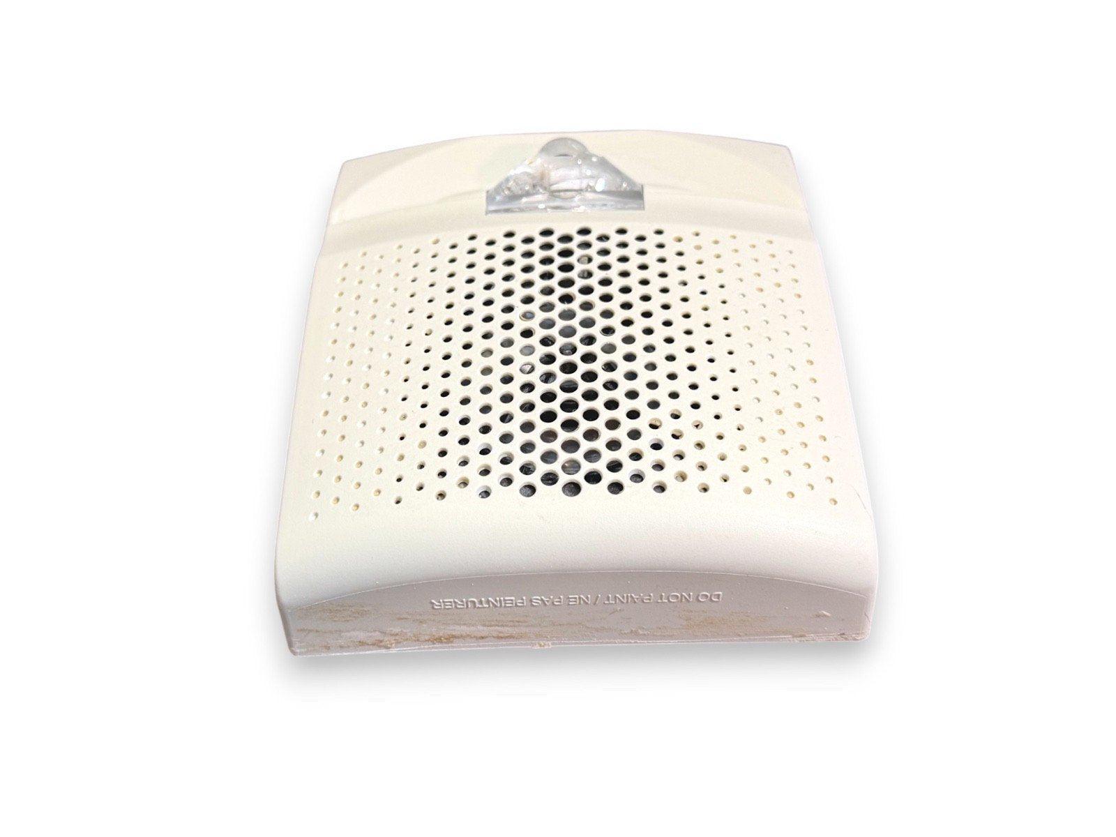 White fire alarm sounder with clear lens and perforated grille, used fire alarm equipment
