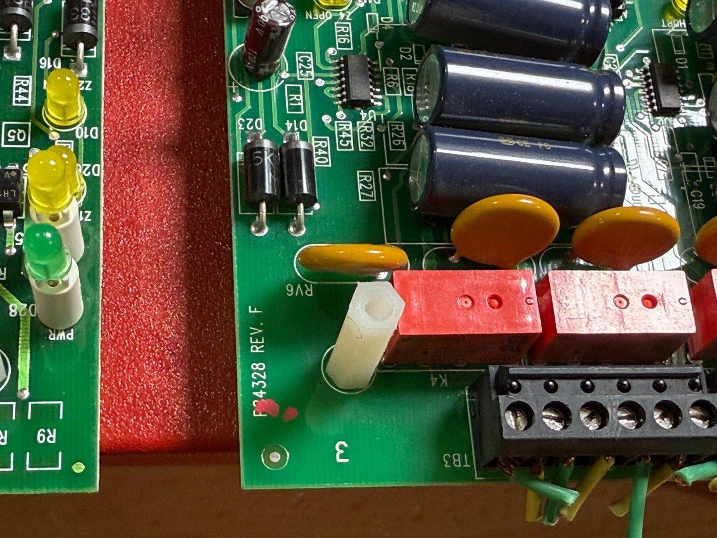 Fire alarm control panel circuit board with LEDs, capacitors, and terminal block for fire safety systems