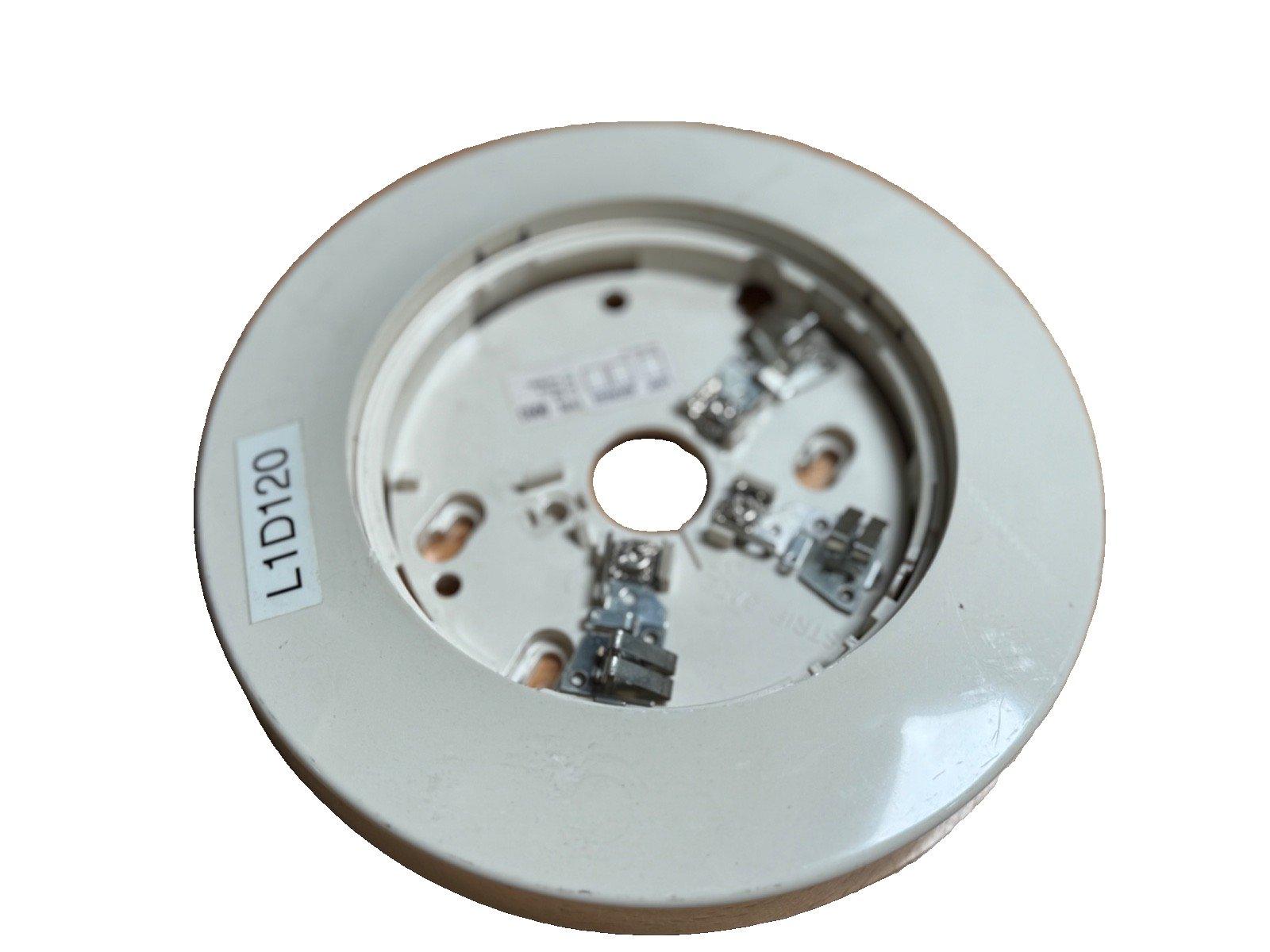 White fire alarm base with L1D120 label, showing internal wiring terminals for fire safety systems